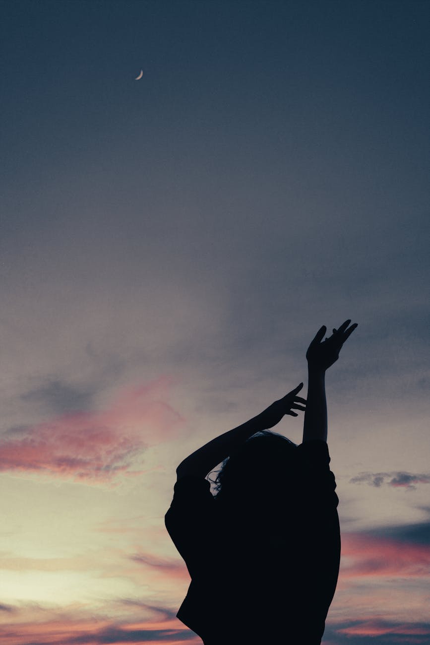 silhouette of person raising her hands